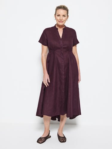 Woman wearing a Commonry plum dress on a white background